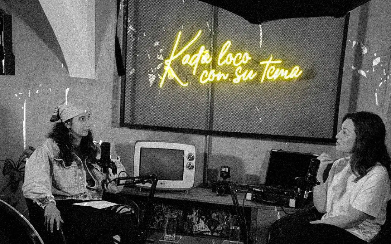 Equipo de Kada Loco con su Tema en el estudio bajo el letrero de neón