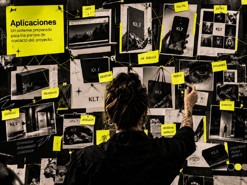 Persona organizando las aplicaciones de una marca en un muro