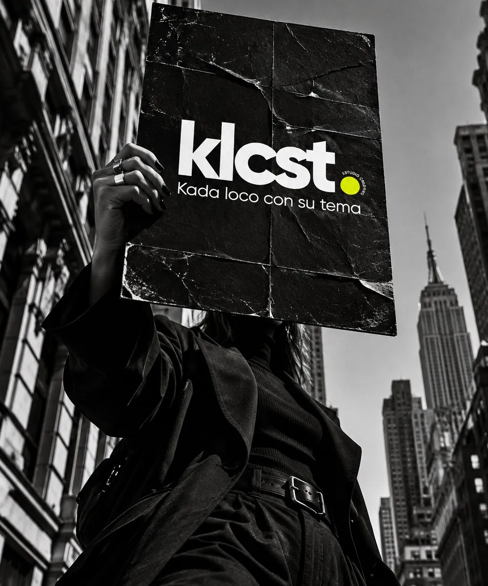 Persona sosteniendo un cartel de klcst entre rascacielos